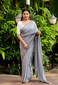 Grey poly georgette saree with woven white leaf pattern and mirror work blouse