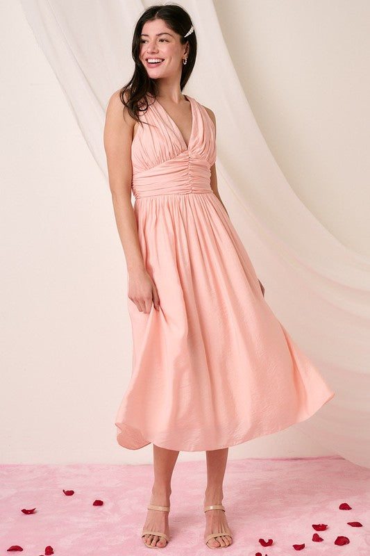 Sleek sleeveless midi dress featuring a deep V-neck and ruched waist detailing.