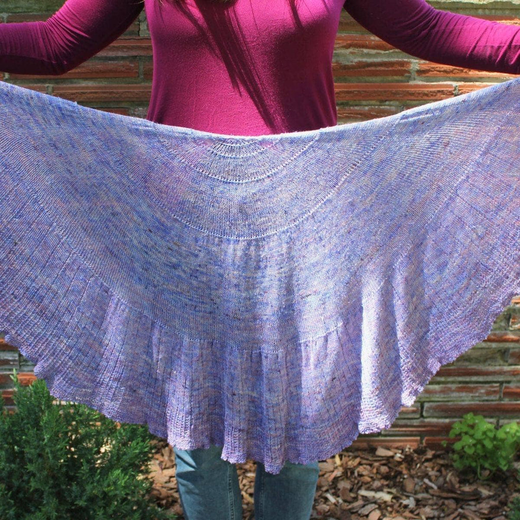 Close up of a periwinkle and lavender scalloped knit shawl.