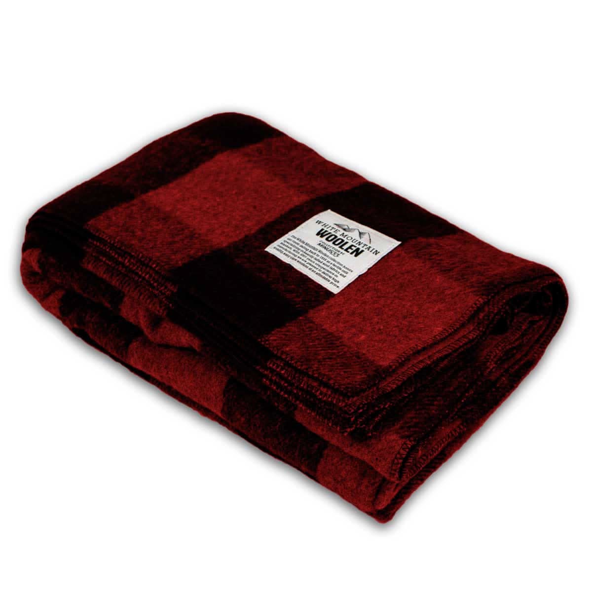 A folded buffalo plaid wool camp blanket draped over a chair, perfect for camping or home comfort.