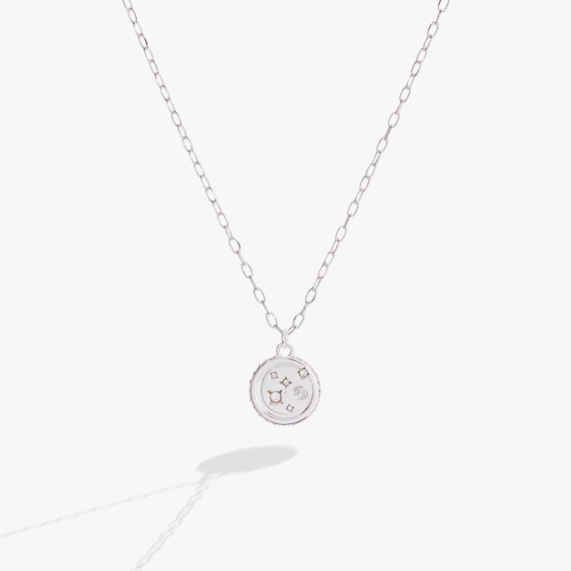 Close up of a Cancer zodiac charm necklace in polished sterling silver with crystal accents on a cable chain.