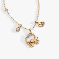 Gold-plated Cancer zodiac necklace with crystal-pave charm, crab charm, and water-drop crystal.