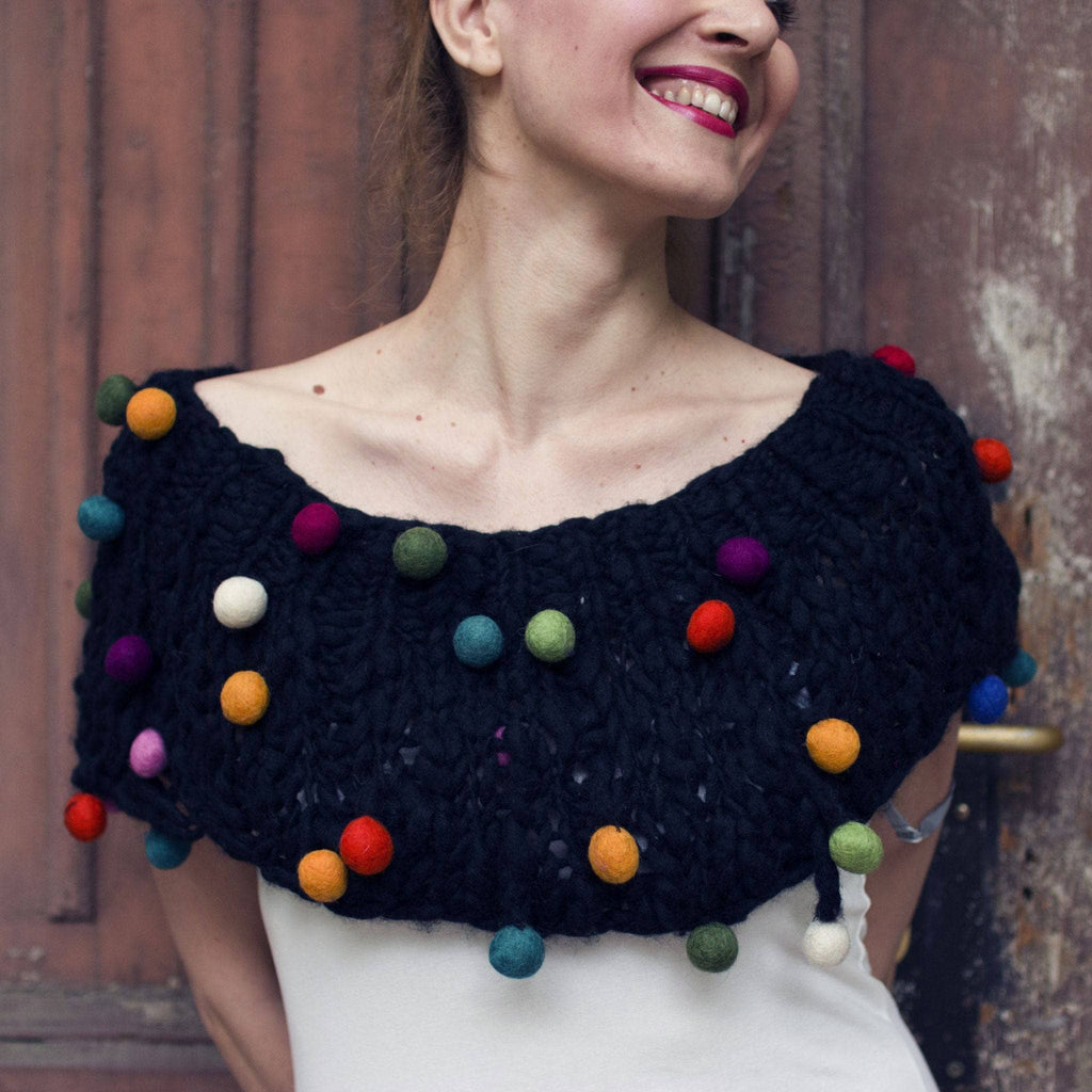 A stylish hand-knitted cowl from the CaPowl knitting kit in black and multi-color yarn.