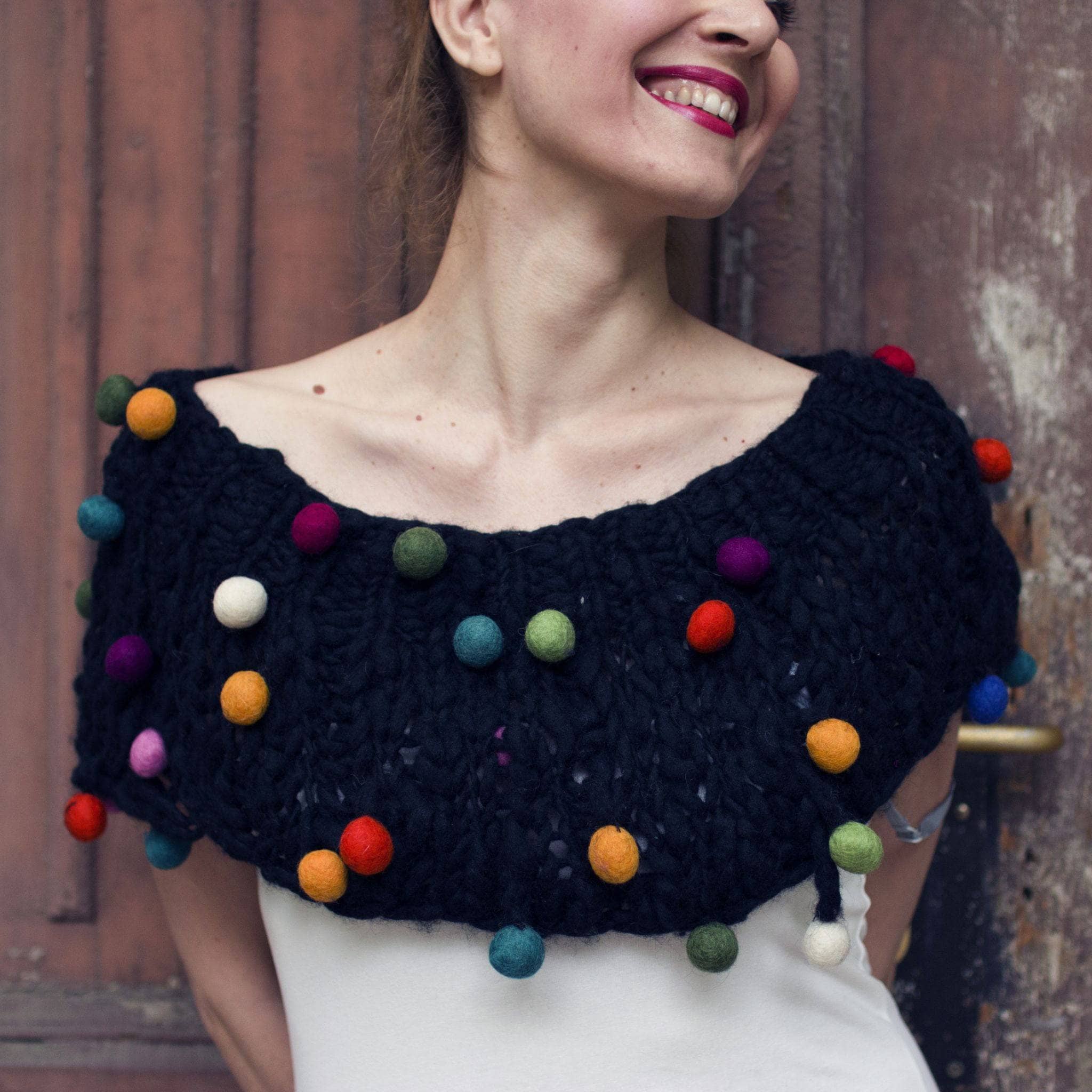 A stylish hand-knitted cowl from the CaPowl knitting kit in black and multi-color yarn.
