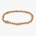Gold-tone beaded stretch bracelet with pretzel, croissant, and pasta charms