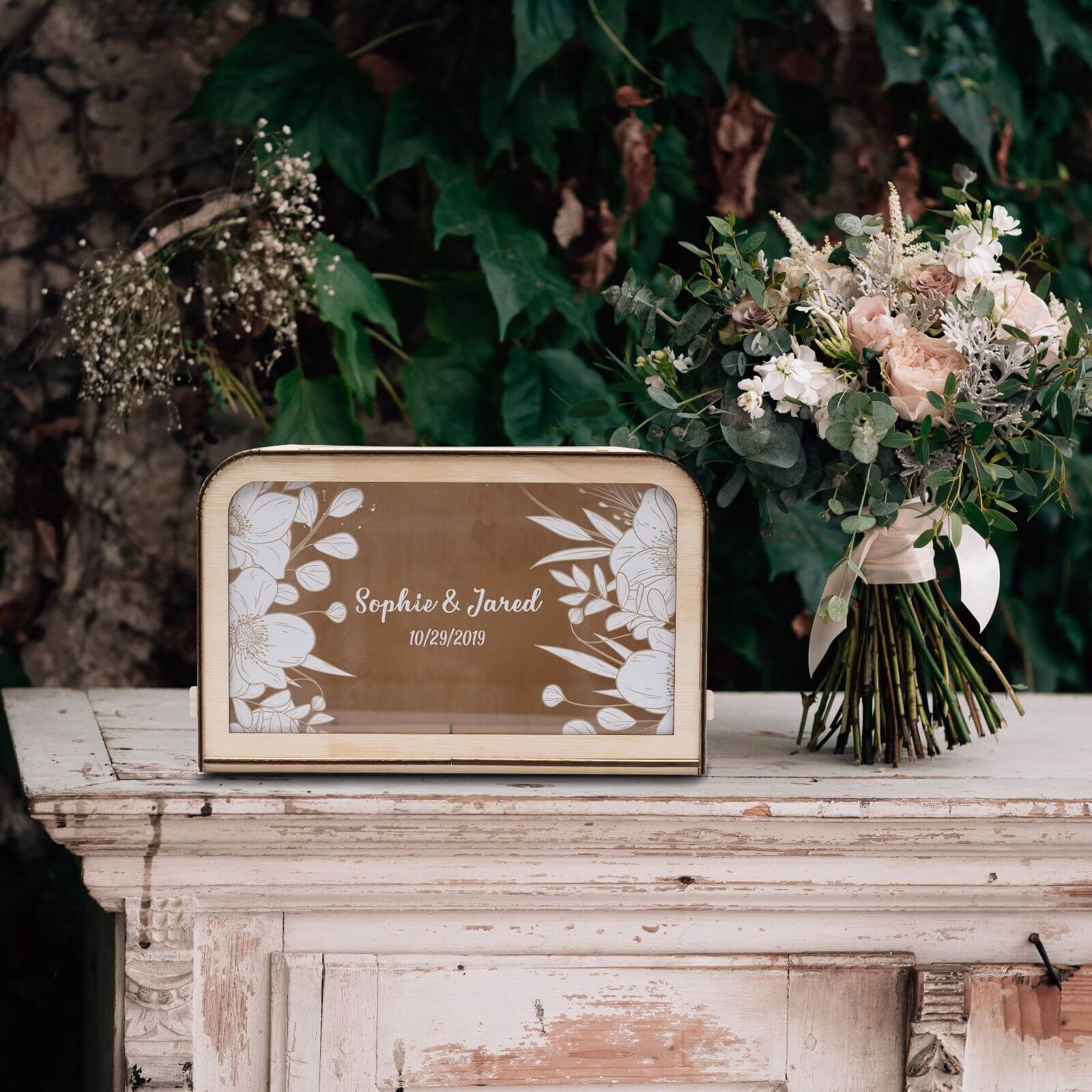 Rustic wooden wedding card box with white botanical floral art, 10x8 inches, on a wedding gift table.
