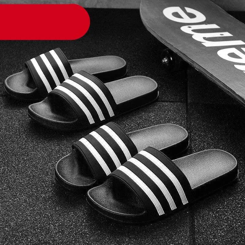 A pair of black and white striped summer slides for men and women