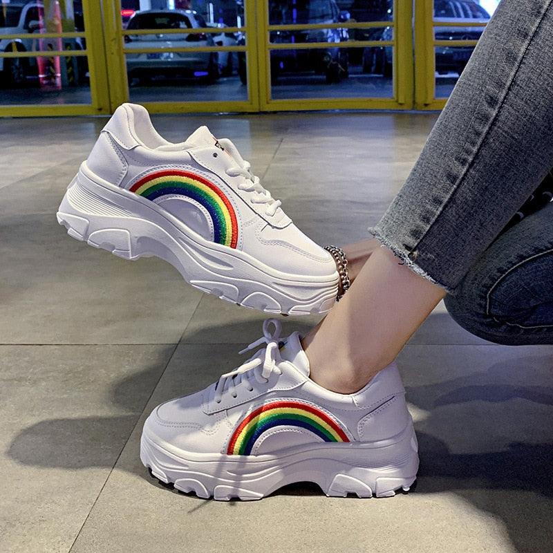 Women's chunky white winter platform sneakers with colorful rainbow detailing and a thick rubber sole.