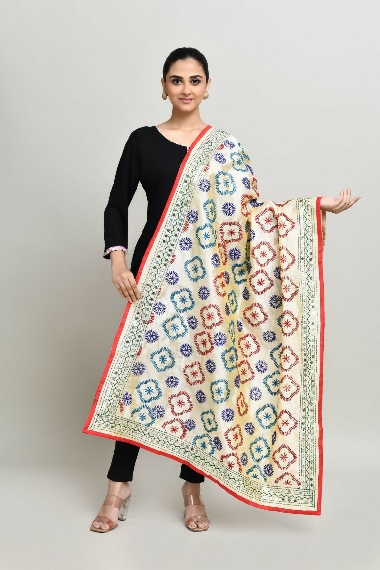 A close-up of a multi-color Phulkari dupatta with vibrant red, navy, and blue embroidery on an off-white cotton base.