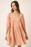 Peach colored pintuck mini dress with a tie back detail and romantic aesthetic