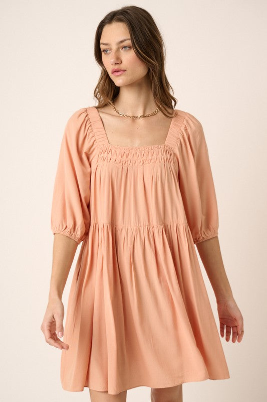 Peach colored pintuck mini dress with a tie back detail and romantic aesthetic