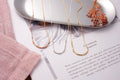 Minimalist Morse Code custom name necklace with delicate metallic detailing.