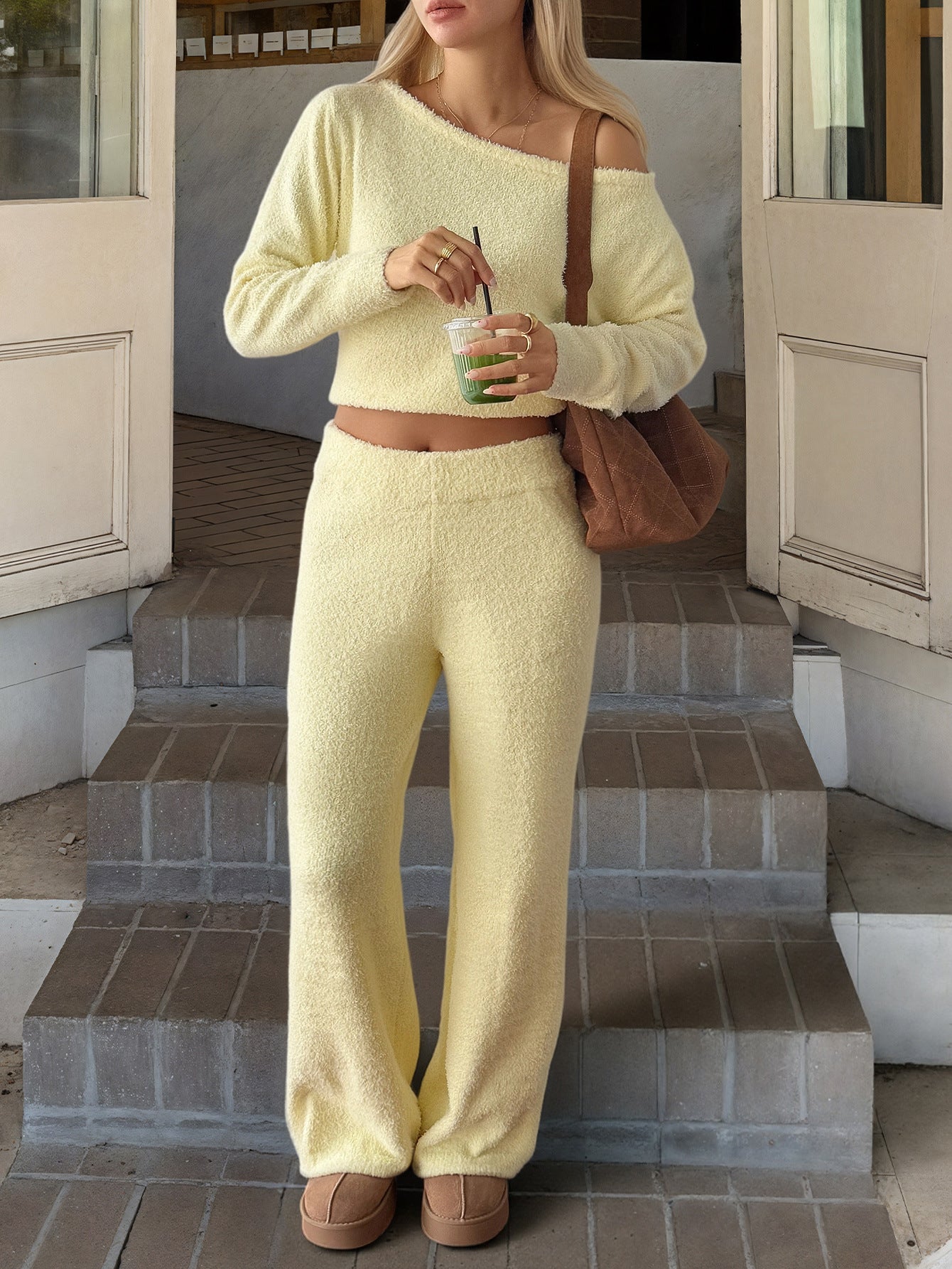 A woman wearing a minimalist long-sleeve knit sweater and matching trousers lounge set