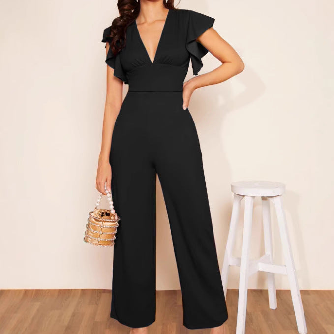A woman wearing a high-waist black jumpsuit with ruffle sleeves and a v-neckline
