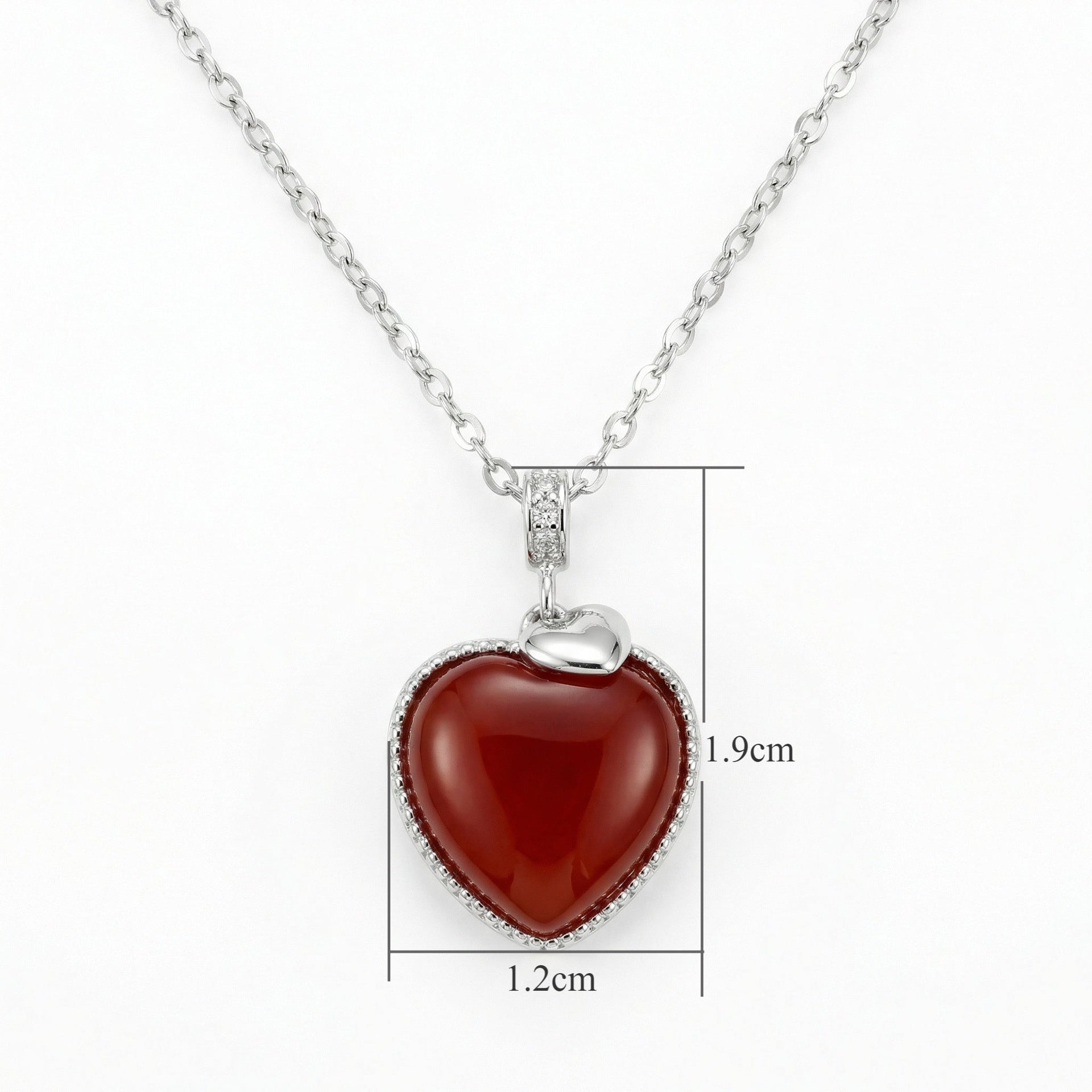 Close up of a 925 Sterling Silver heart necklace featuring a vibrant red gemstone pendant with clear crystals.