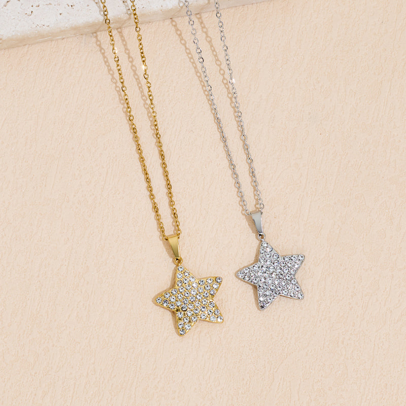 A gold star pendant necklace with sparkling zircon inlay sitting on a white background.