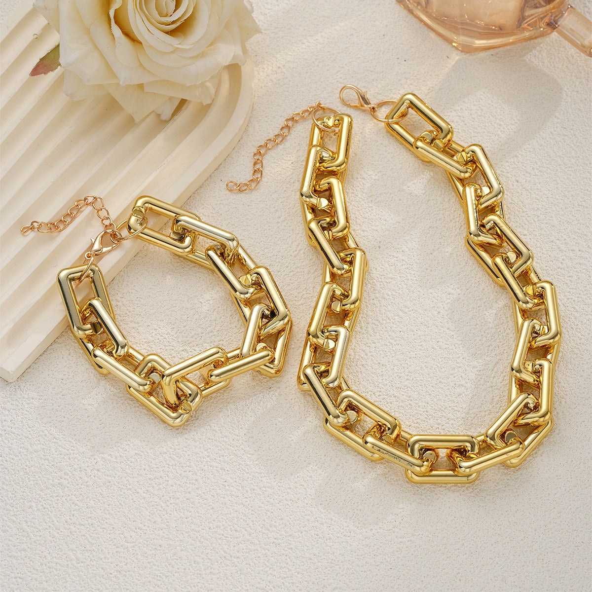 Matching geometric chunky rectangular chain necklace and bracelet set in gold.