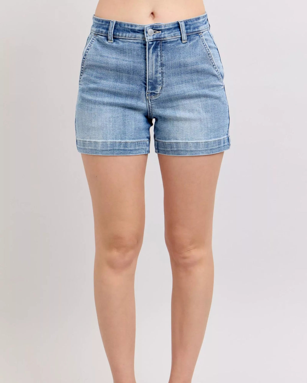 Person wearing light blue denim shorts on a plain background