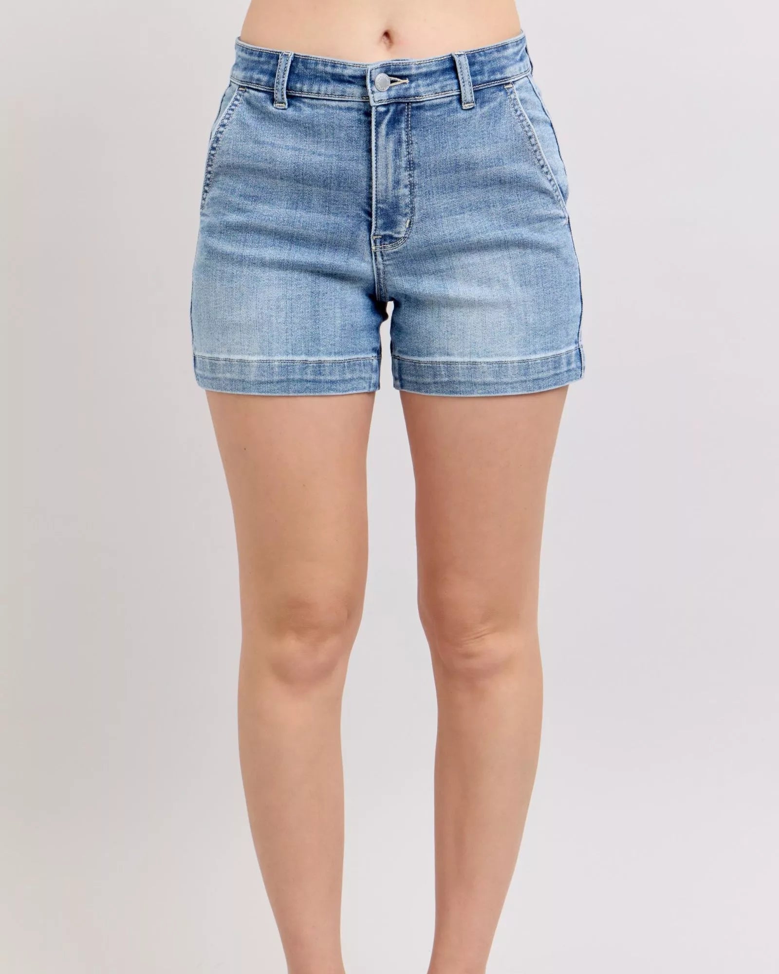 Person wearing light blue denim shorts on a plain background