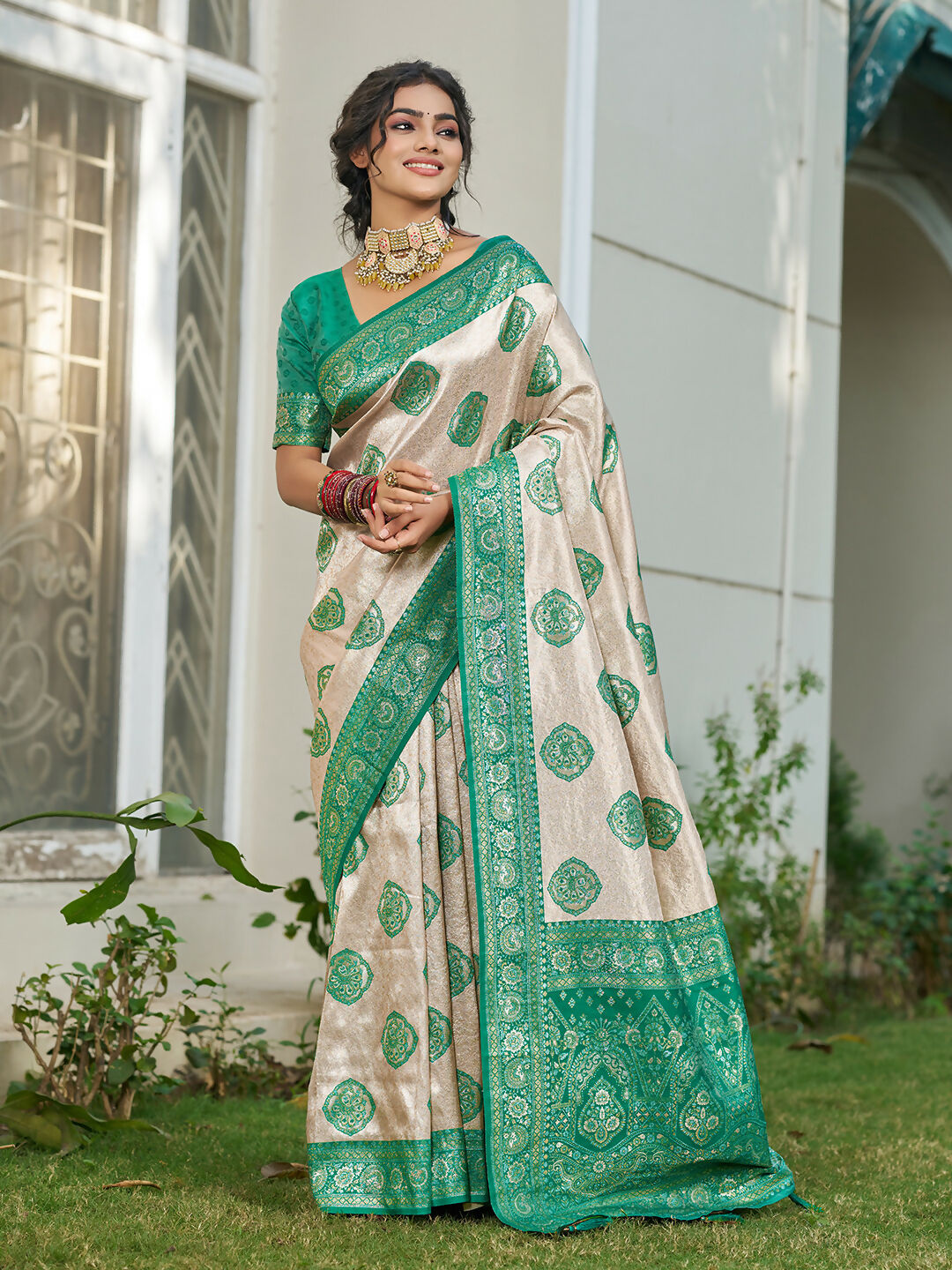 Cream and sea green silk blend saree with a traditional finish.