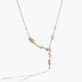 Champagne bottle and flute pendant necklace featuring pearls and clear crystals on an adjustable chain.