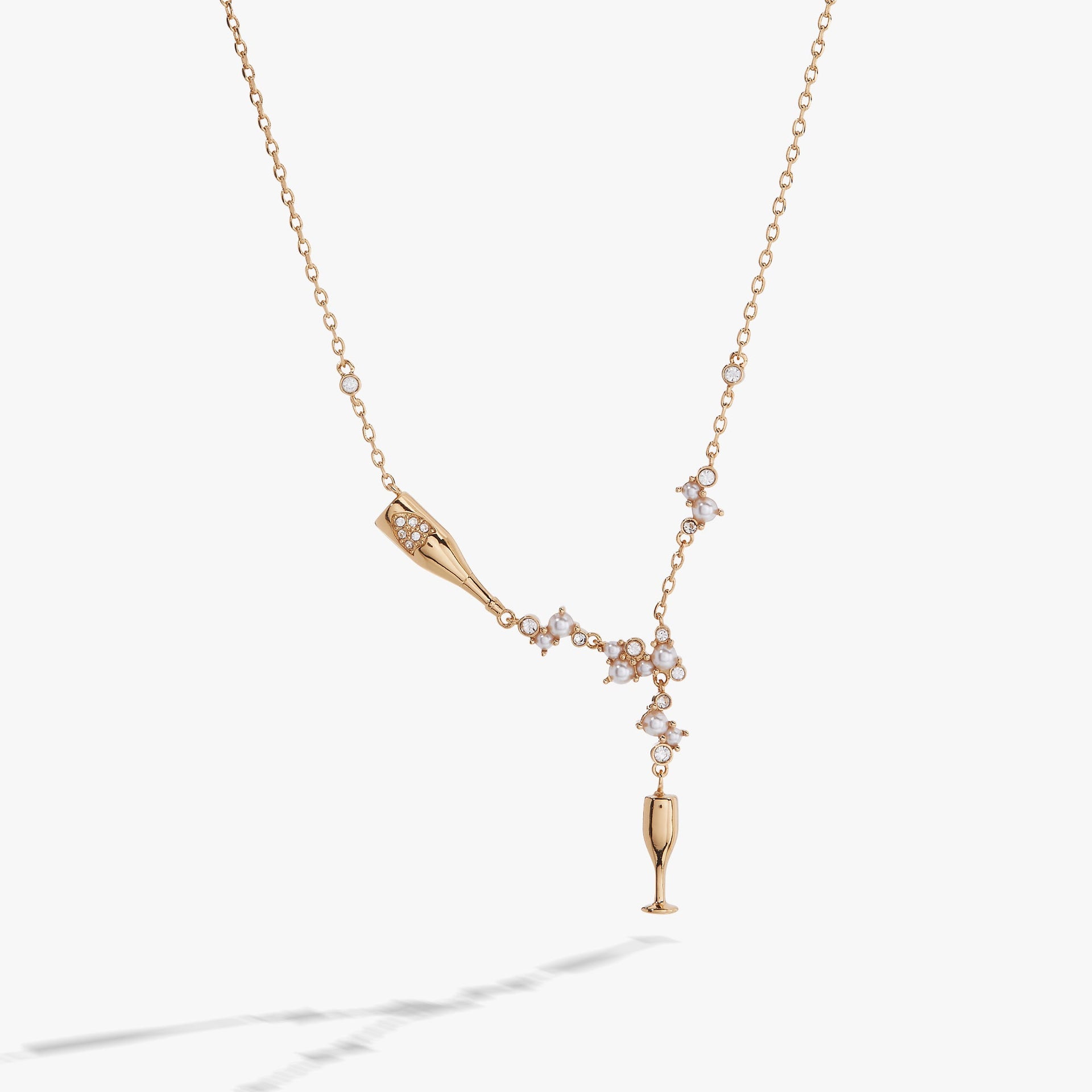 Champagne bottle and flute pendant necklace featuring pearls and clear crystals on an adjustable chain.