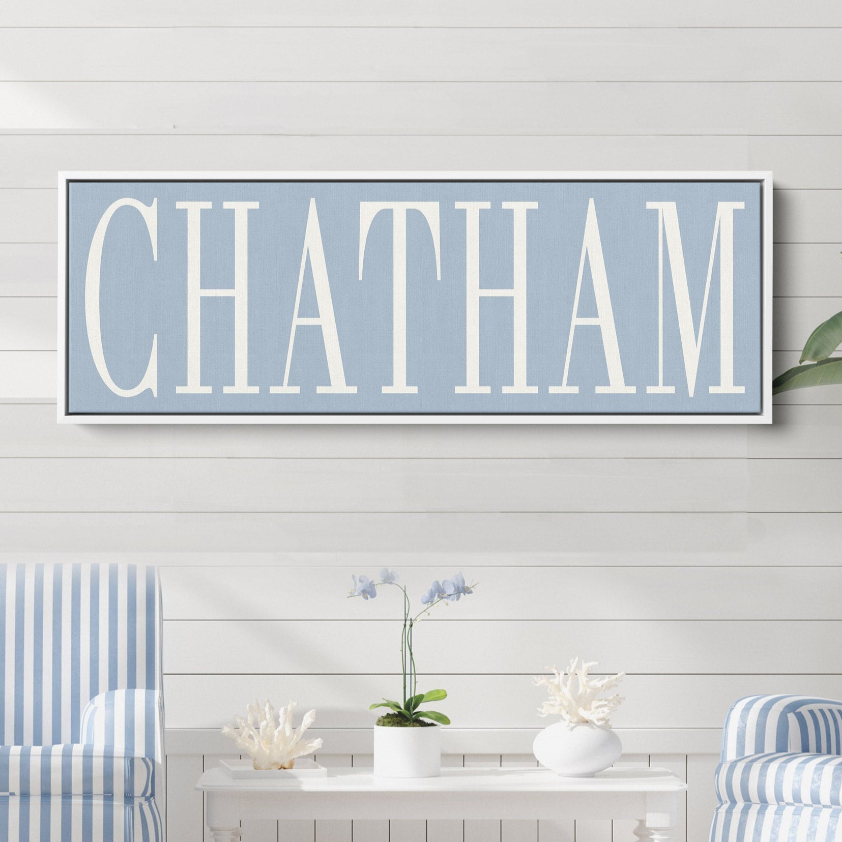 A personalized framed canvas sign featuring a custom city and family name hanging on a wall.