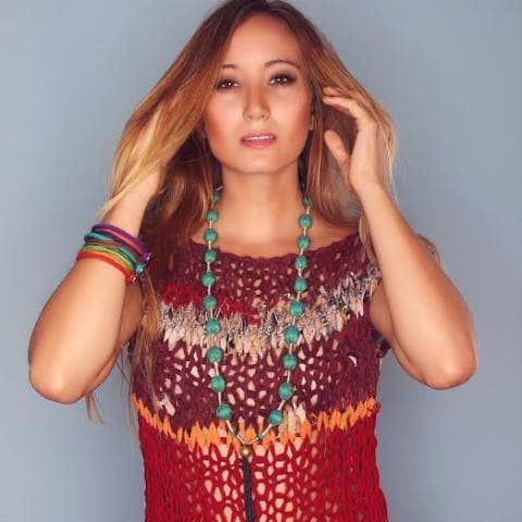Woman wearing a vibrant multi-colored knit boho cover-up top at the beach