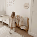 Wooden clothing rack for children placed in a bedroom
