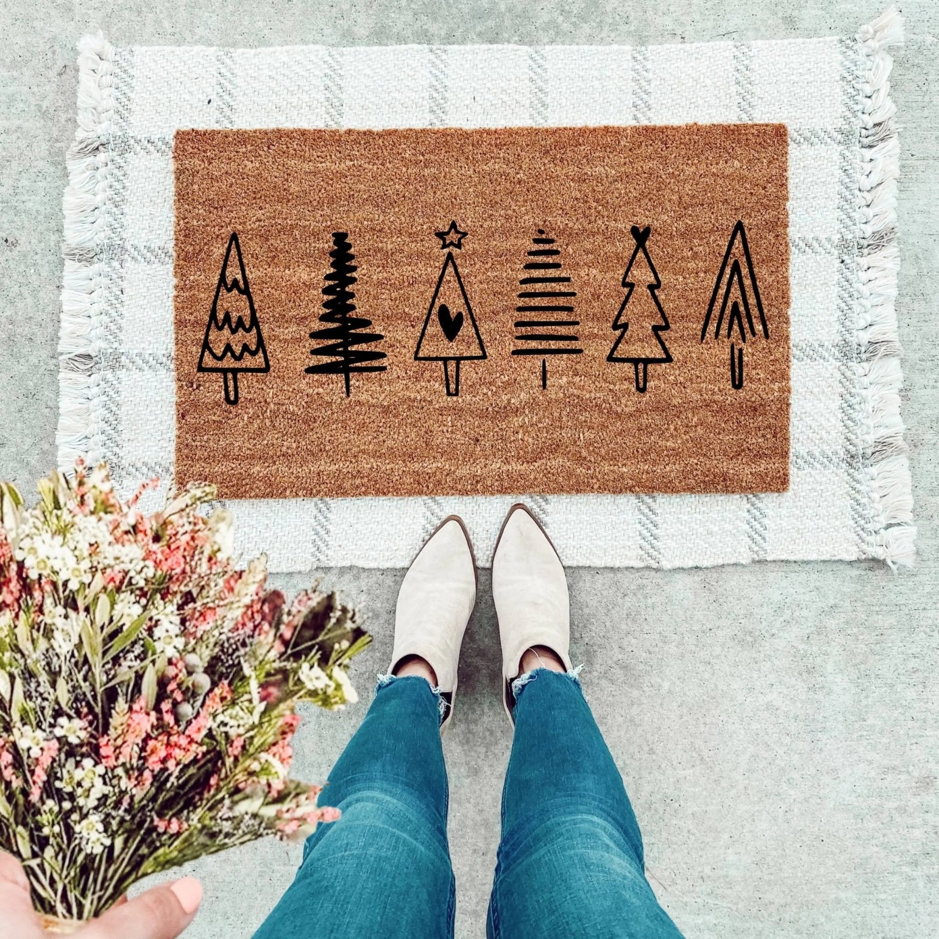 Minimalist farmhouse Christmas tree doormat with black graphic print on natural coir on an outdoor front porch