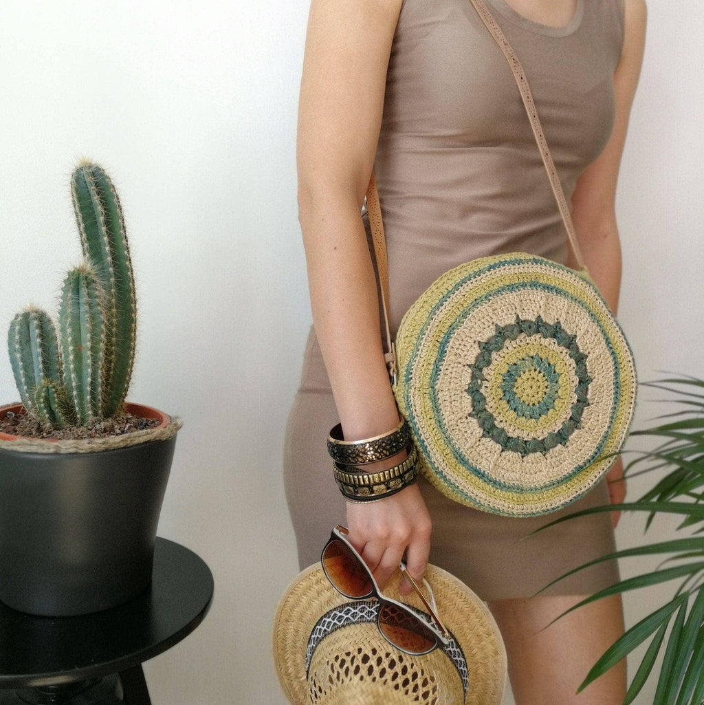 A boho-chic circular crochet banjo bag made from colorful recycled silk yarn
