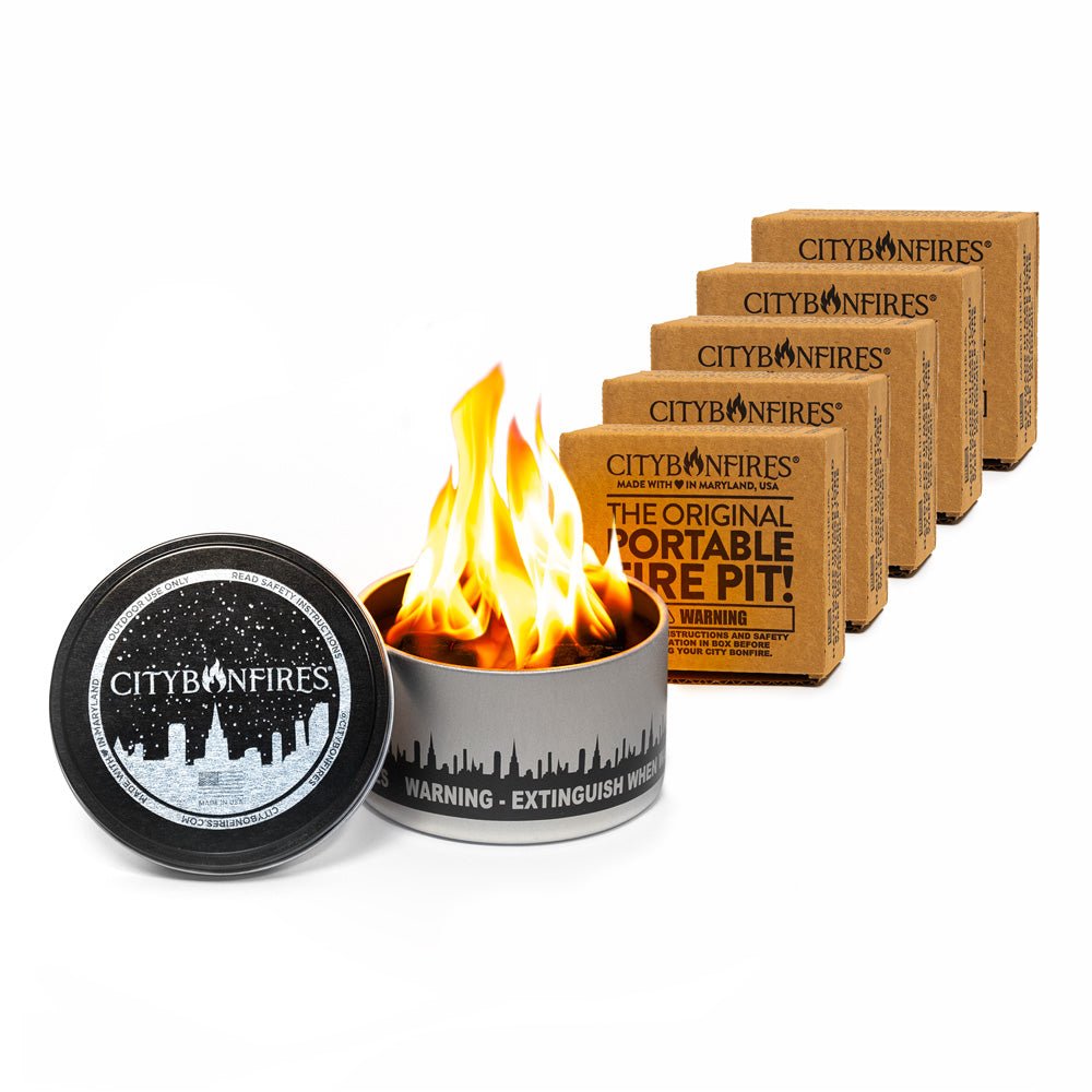 A set of five portable metallic silver and brown metal fire pits arranged for outdoor use.