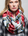 Woman wearing a colorful classic woven plaid infinity scarf over a winter coat
