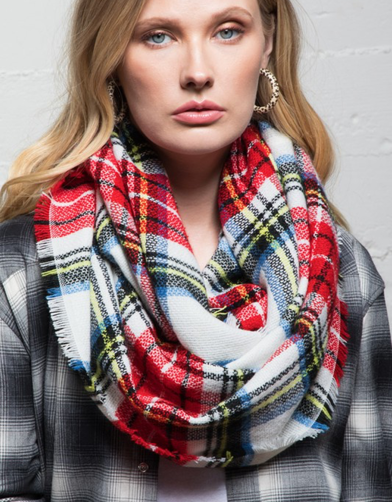 Woman wearing a colorful classic woven plaid infinity scarf over a winter coat