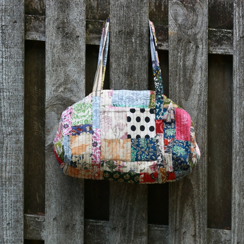 Colorful handmade patchwork quilted duffle bag featuring bohemian patterns and sustainable recycled fabrics.