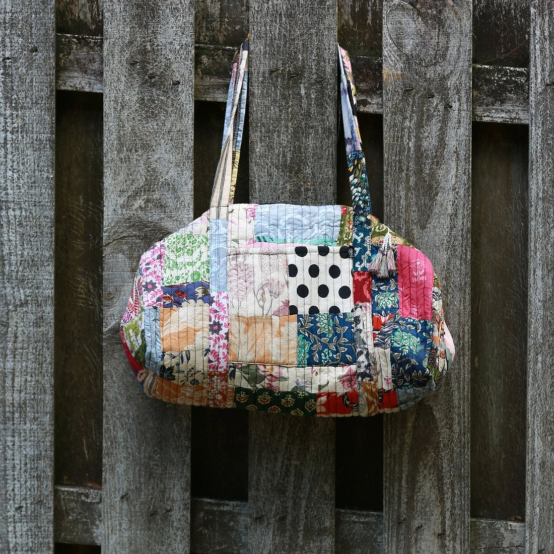 Colorful handmade patchwork quilted duffle bag featuring bohemian patterns and sustainable recycled fabrics.