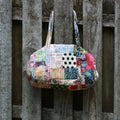 Colorful handmade patchwork quilted duffle bag featuring bohemian patterns and sustainable recycled fabrics.