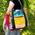A colorful Wanderlust Kantha stitched cotton bag with abstract patterns in yellow, red, blue, and green.