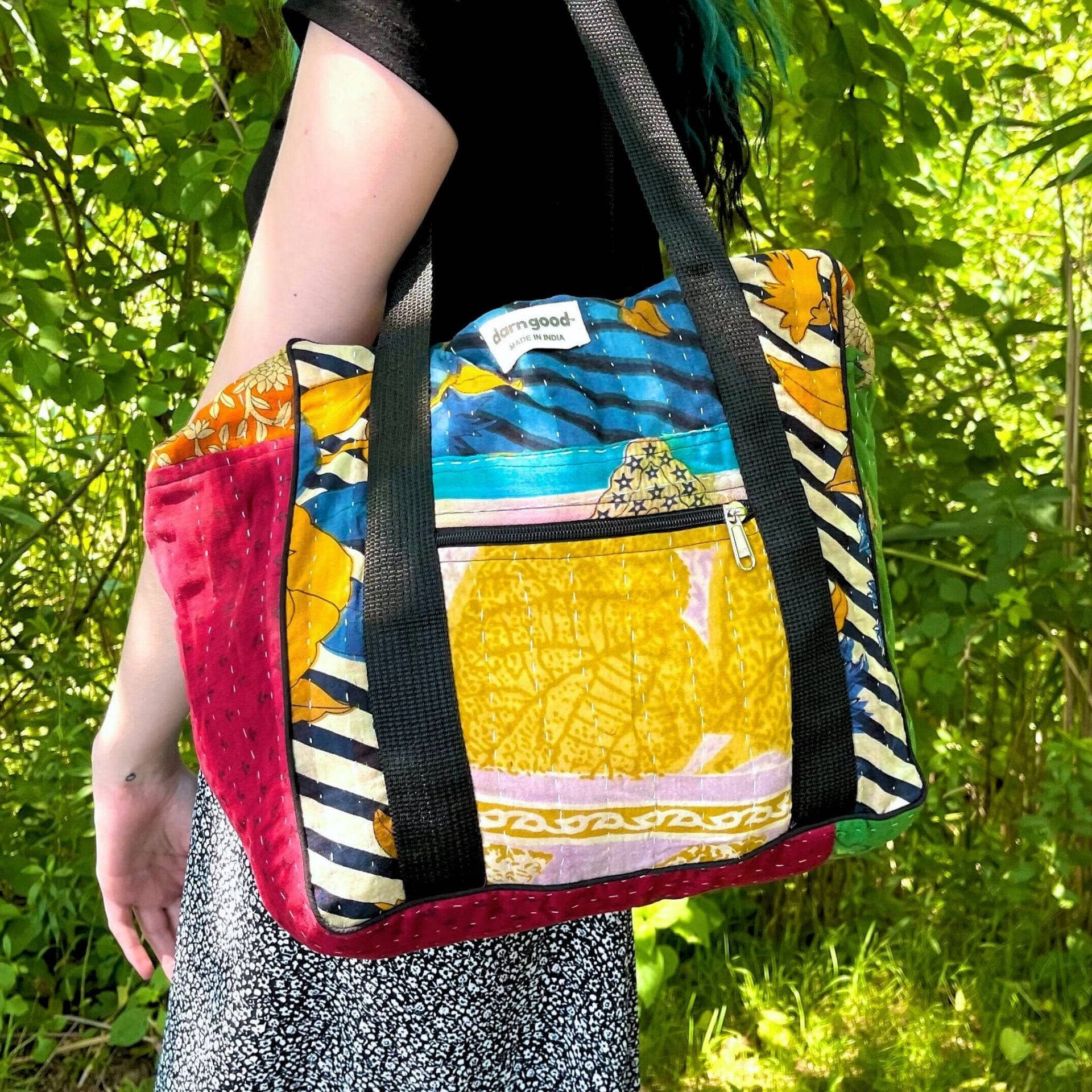 A colorful Wanderlust Kantha stitched cotton bag with abstract patterns in yellow, red, blue, and green.