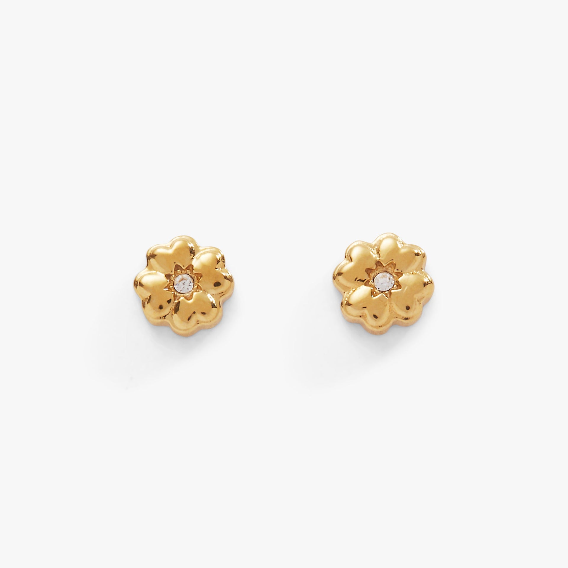 A pair of gold-tone mini stud earrings shaped like four-leaf clovers with clear crystal accents on a white background.
