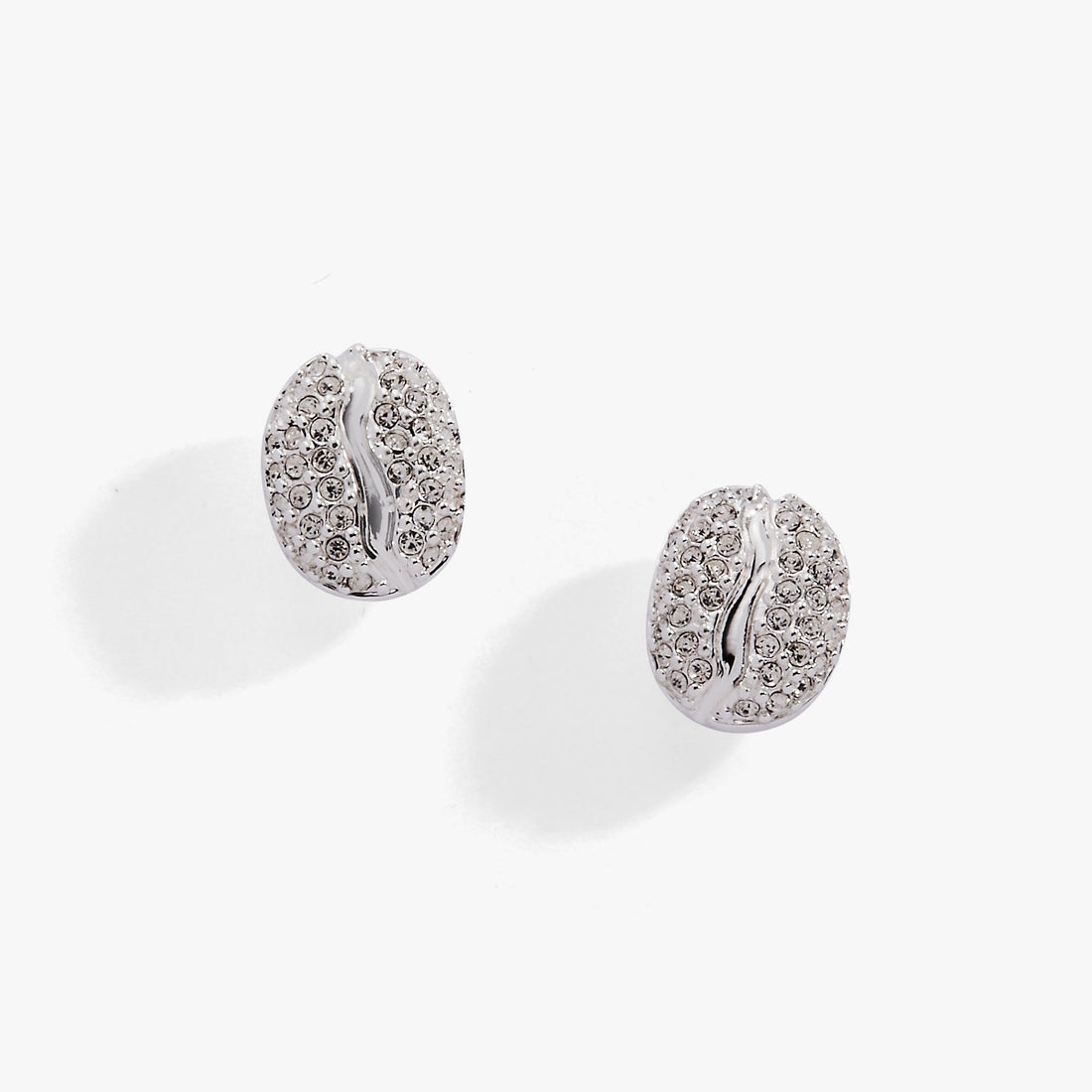 Close-up view of coffee bean shaped silver stud earrings with clear pave crystal detail.