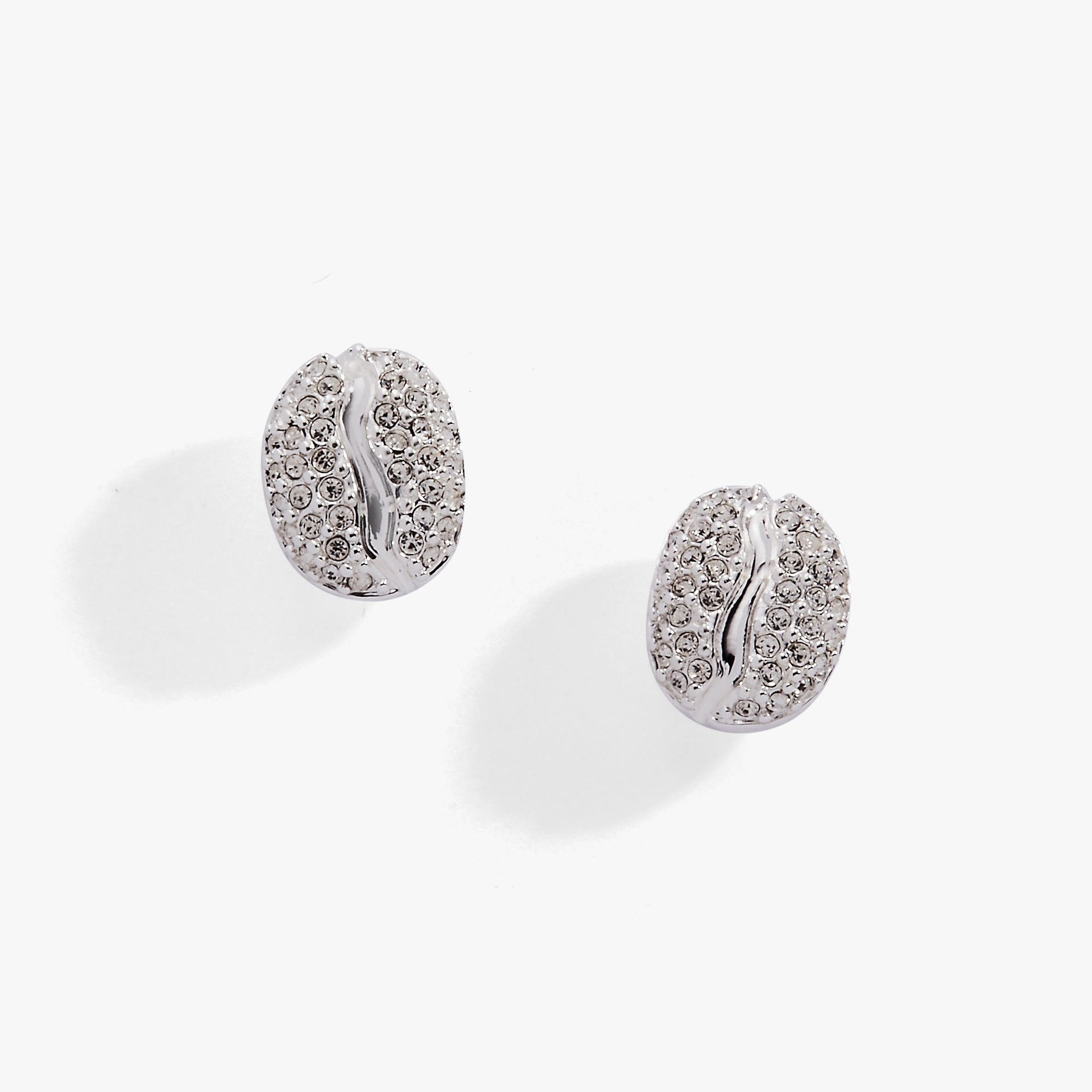 Close-up view of coffee bean shaped silver stud earrings with clear pave crystal detail.