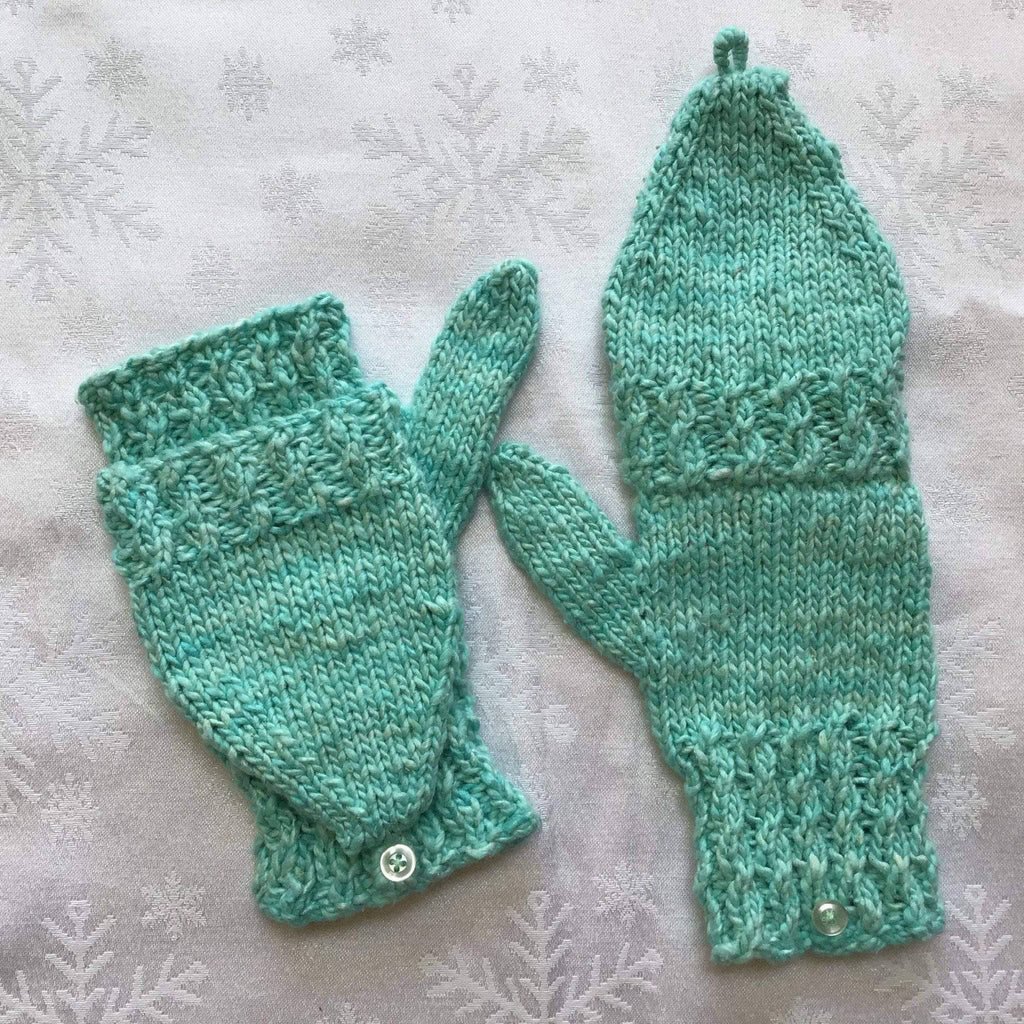 Hand-knitted convertible mittens featuring mock cable texture in a bright color.