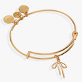 Gold-tone expandable wire bangle featuring a dimensional, minimalist bow charm.