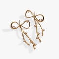 A pair of gold-finished coquette bow earrings with sparkling clear crystal accents.
