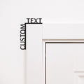 Customizable black wooden wall art quote installed on a room corner.