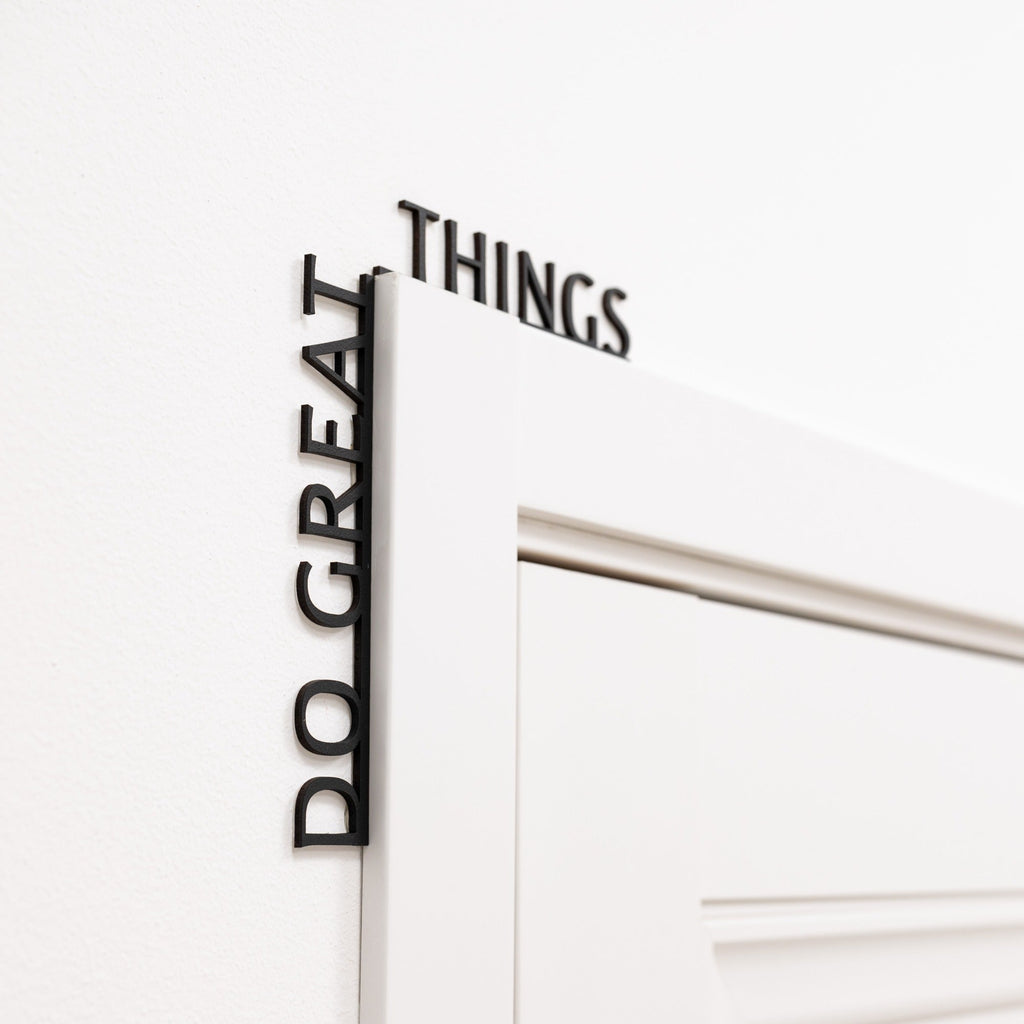 Wooden 'Do Great Things' wall inscription in a modern office corner