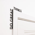Wooden 'Do Great Things' wall inscription in a modern office corner