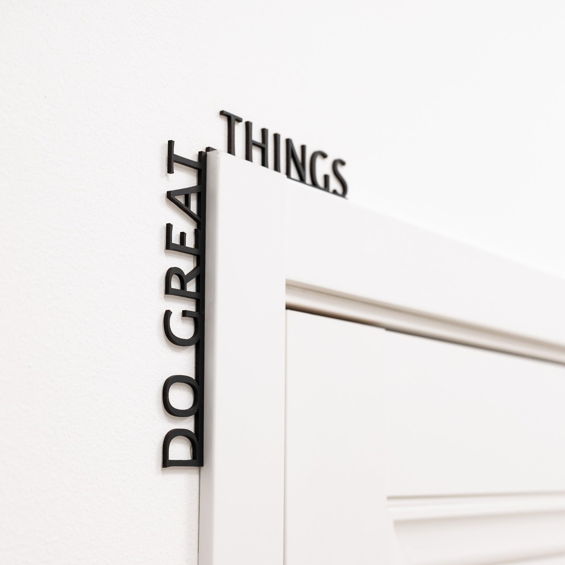 Wooden 'Do Great Things' wall inscription in a modern office corner