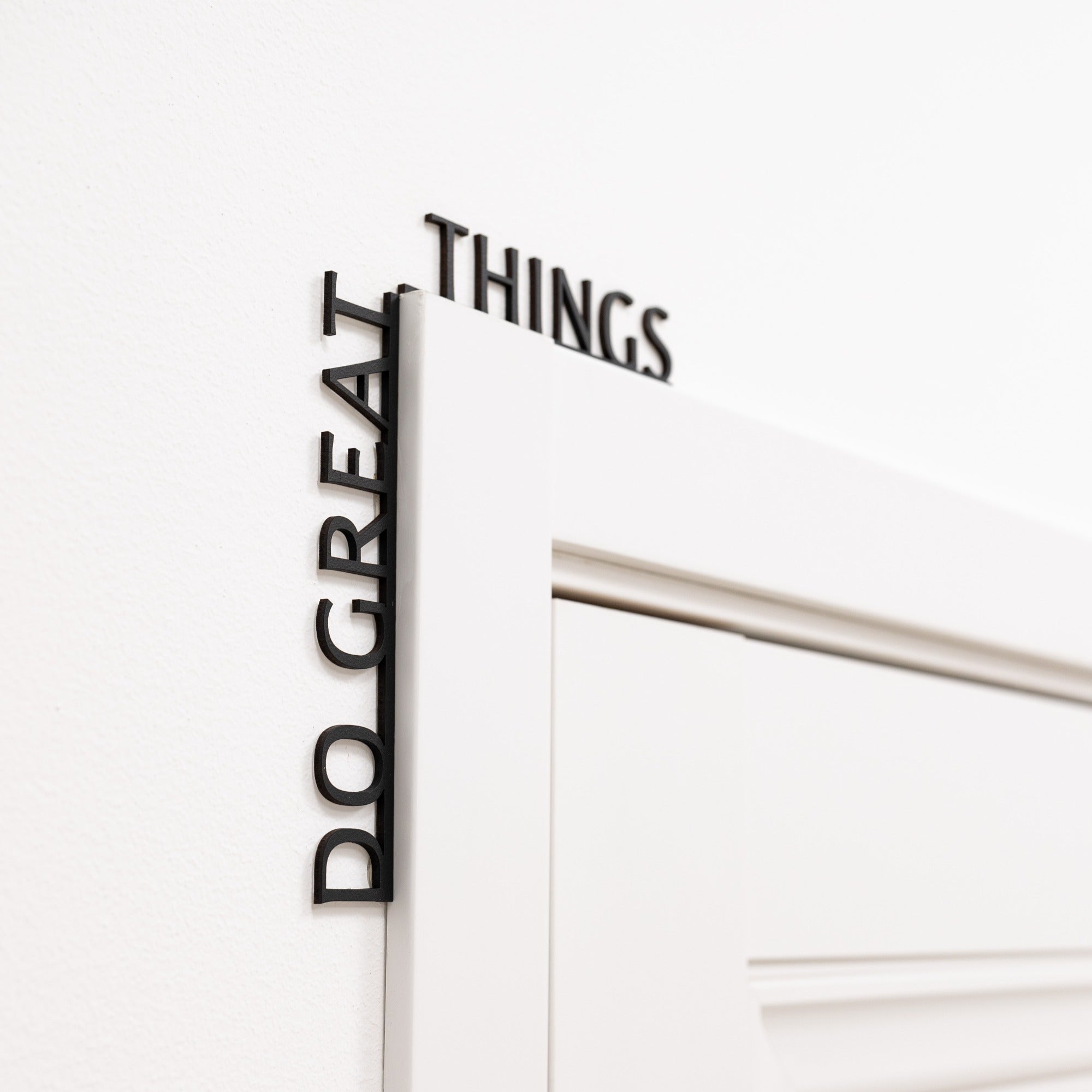 Wooden 'Do Great Things' wall inscription in a modern office corner